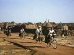 Bicycling past Dogon village, Mali