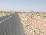 Caution sign before slight curve in the highway, Errichidia, Morocco.