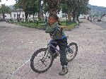 Young female bicyclist in the main square in Quiroga