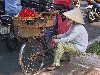 Woman selling berries from bicycle, Saigon