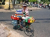 Woman selling water, soda and other drinks from bicycle.